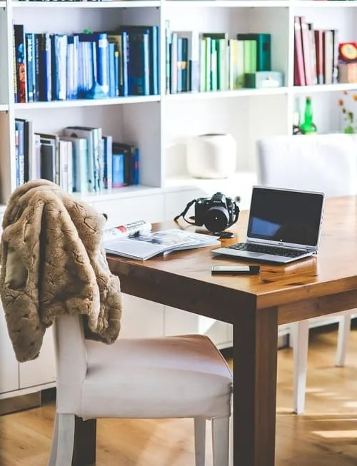 Homeoffice-Arbeitsplatz für Chat-Moderator mit Handy, Laptop und Schreibtisch-Utensilien